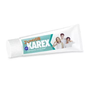 Tube de dentifrice KAREX Junior avec BioHAP, avec des enfants souriants se brossant les dents sur l'emballage.